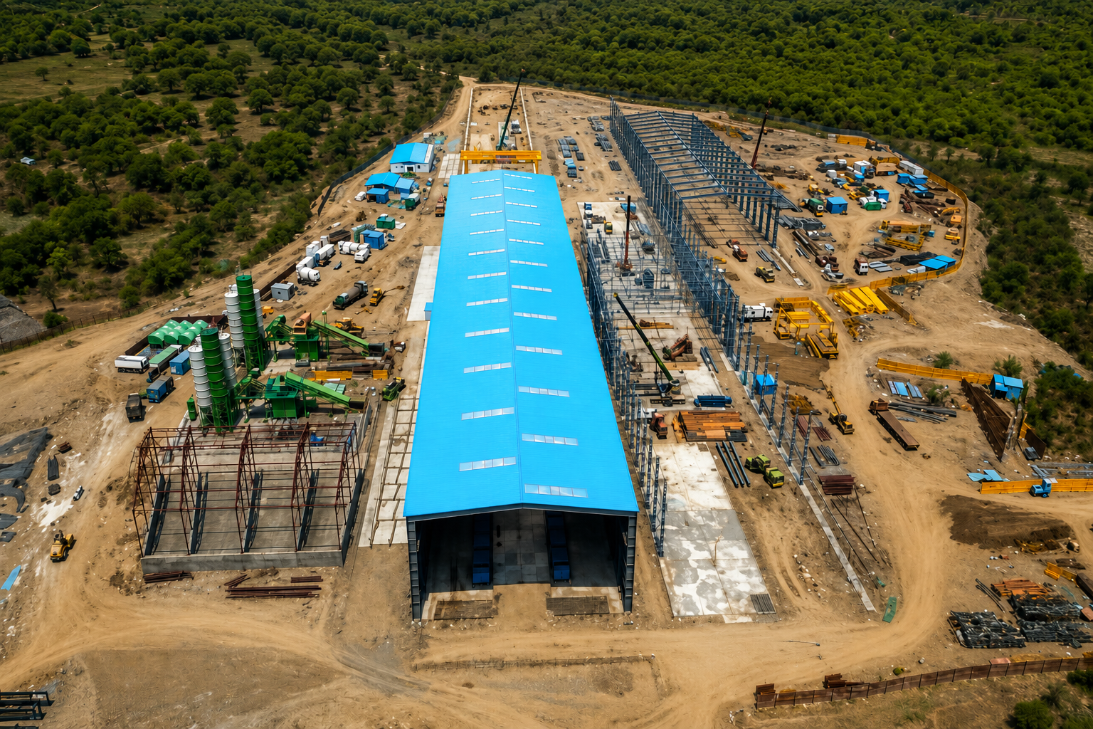 Aerial view of a blue-roofed casting yard and steel fabrication site for bullet train construction